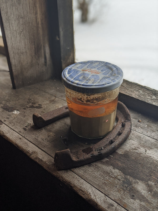 Image of kveik yeast slurry in a jar with a horseshoe around the jar